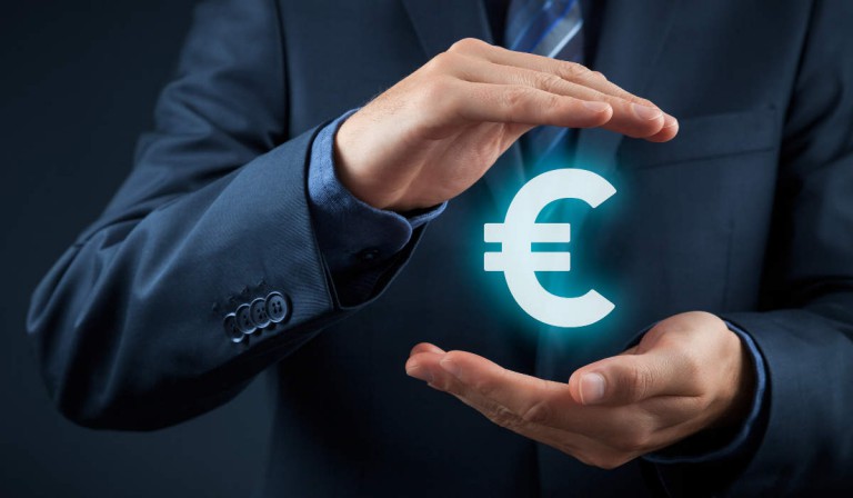 Hellblau leuchtendes Eurozeichen geschützt durch Hände - bildlich für Steuerberatung